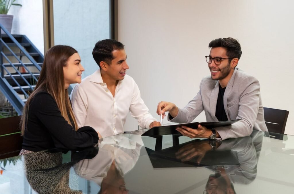 Three people sitting at a table, going through documents together.